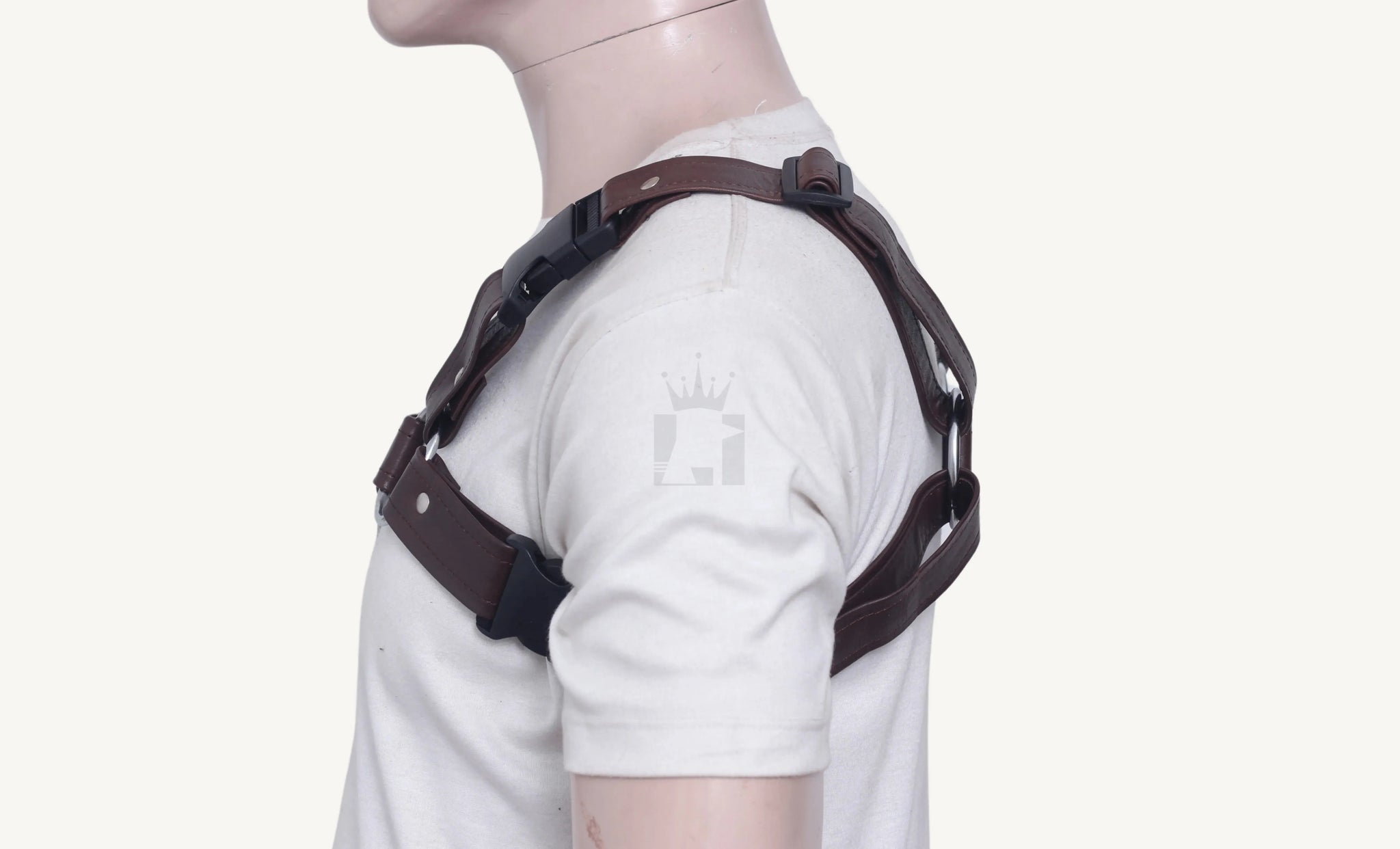 Mannequin side profile displaying brown leather chest harness with silver O-rings and secure buckle strap.