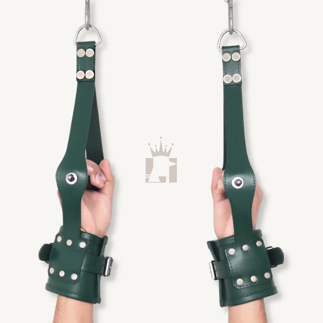 Back view of hands in green leather wrist suspension cuffs showing buckles and straps from behind.