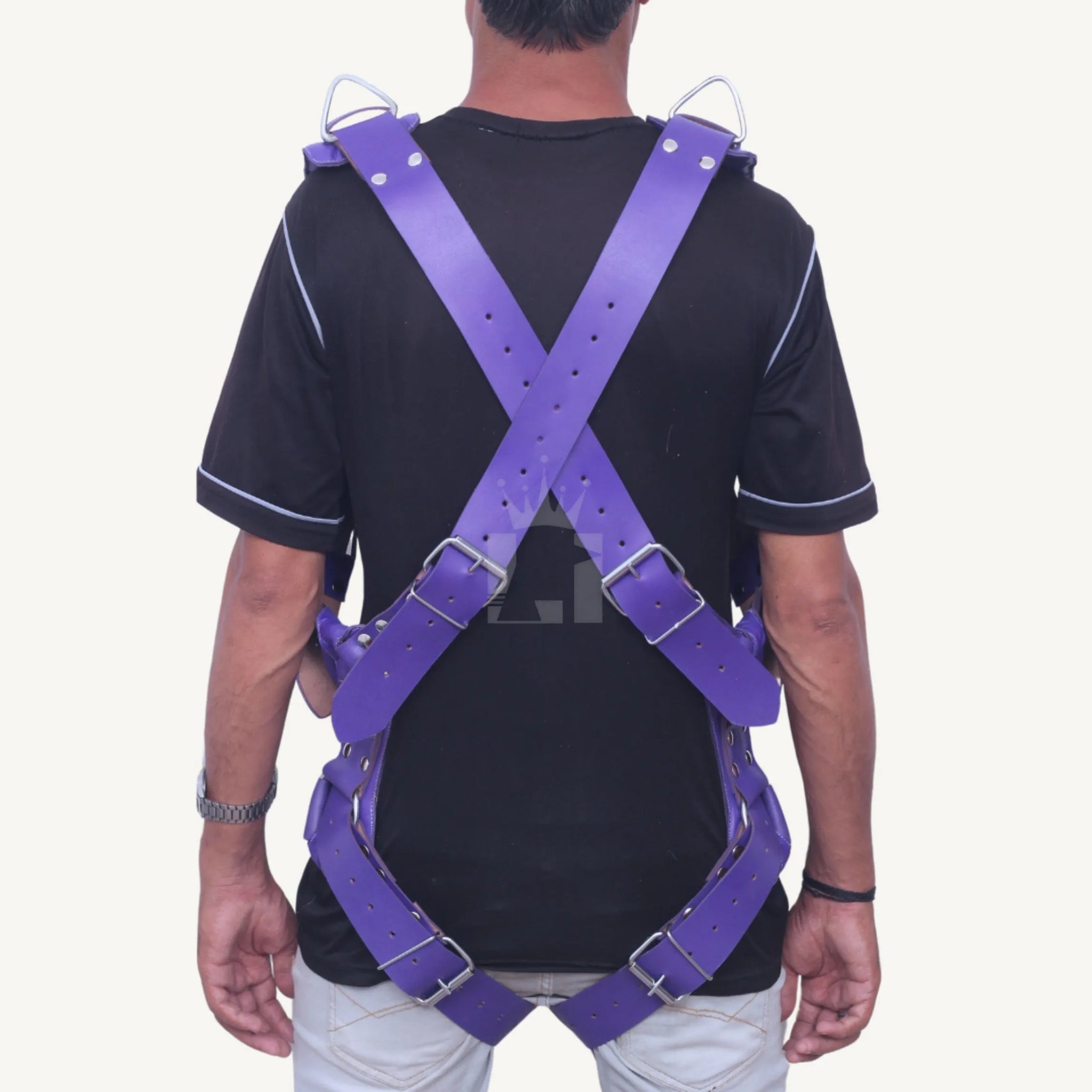 Rear view of a man wearing a purple leather Sex Sling with crossed straps and adjustable buckles.