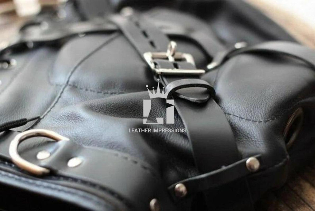 Close-up shot of a blurry background while focusing on a handcrafted black Leather Bondage Hood with Adjustable Straps on a wooden table 