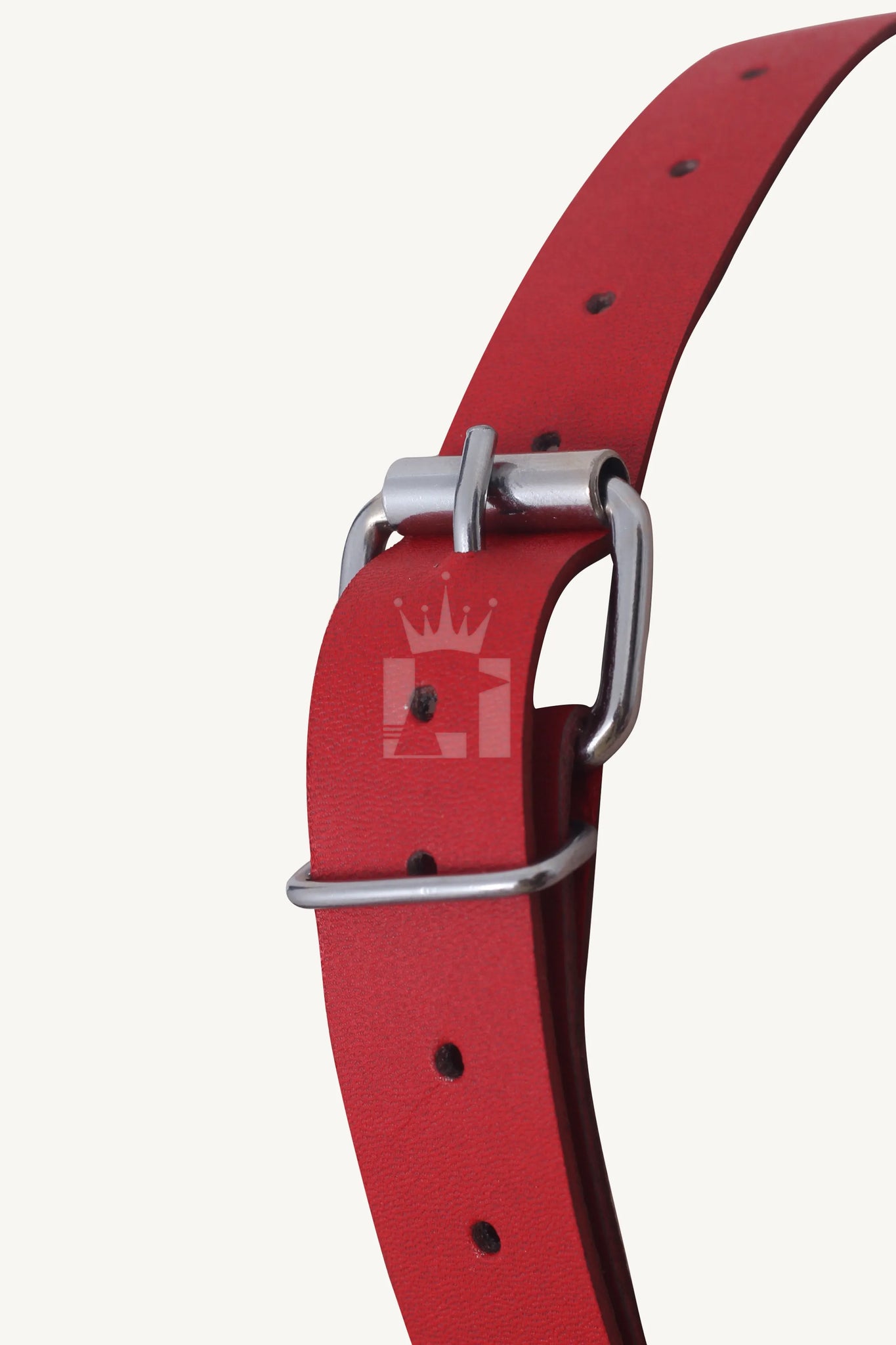 Close-up of silver buckle fastening on red leather bondage muzzle strap.