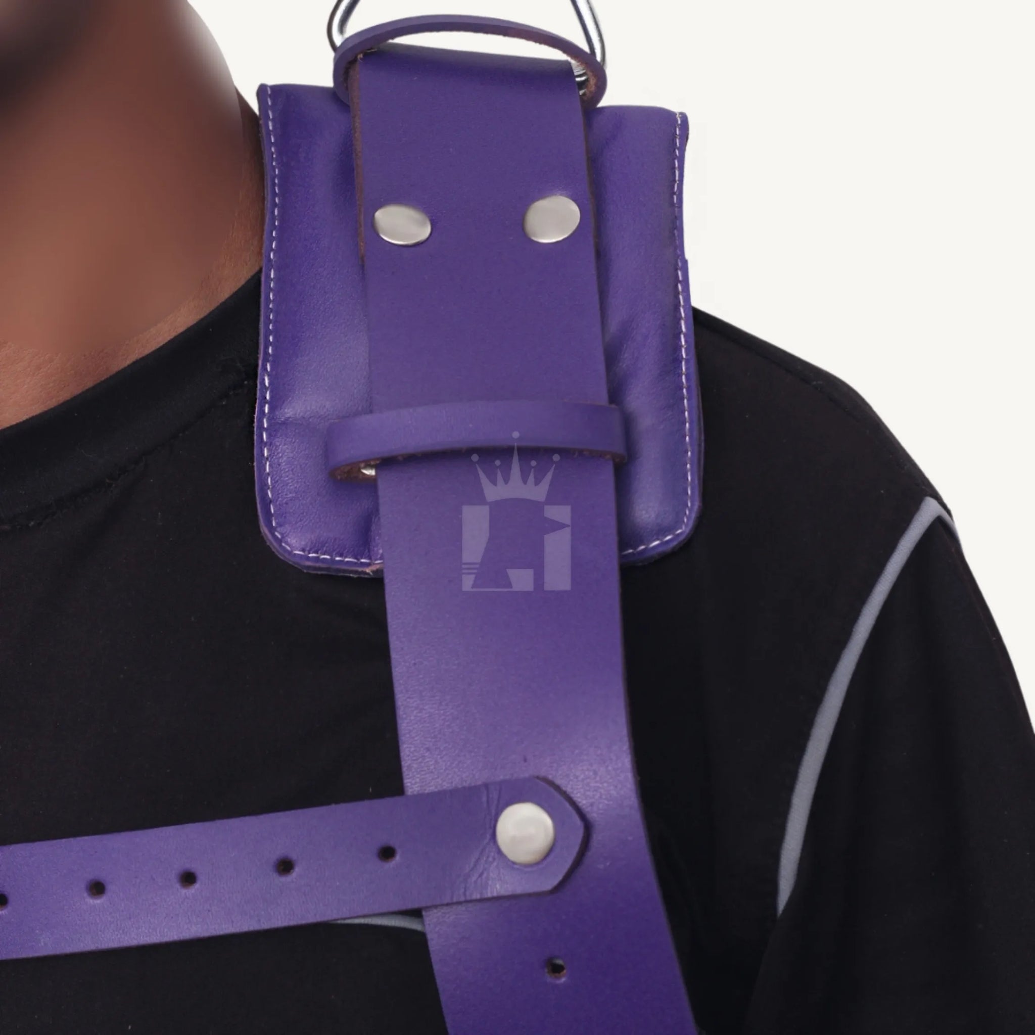 Detailed close-up of padded shoulder strap with rivets and buckle on a purple leather sex sling.