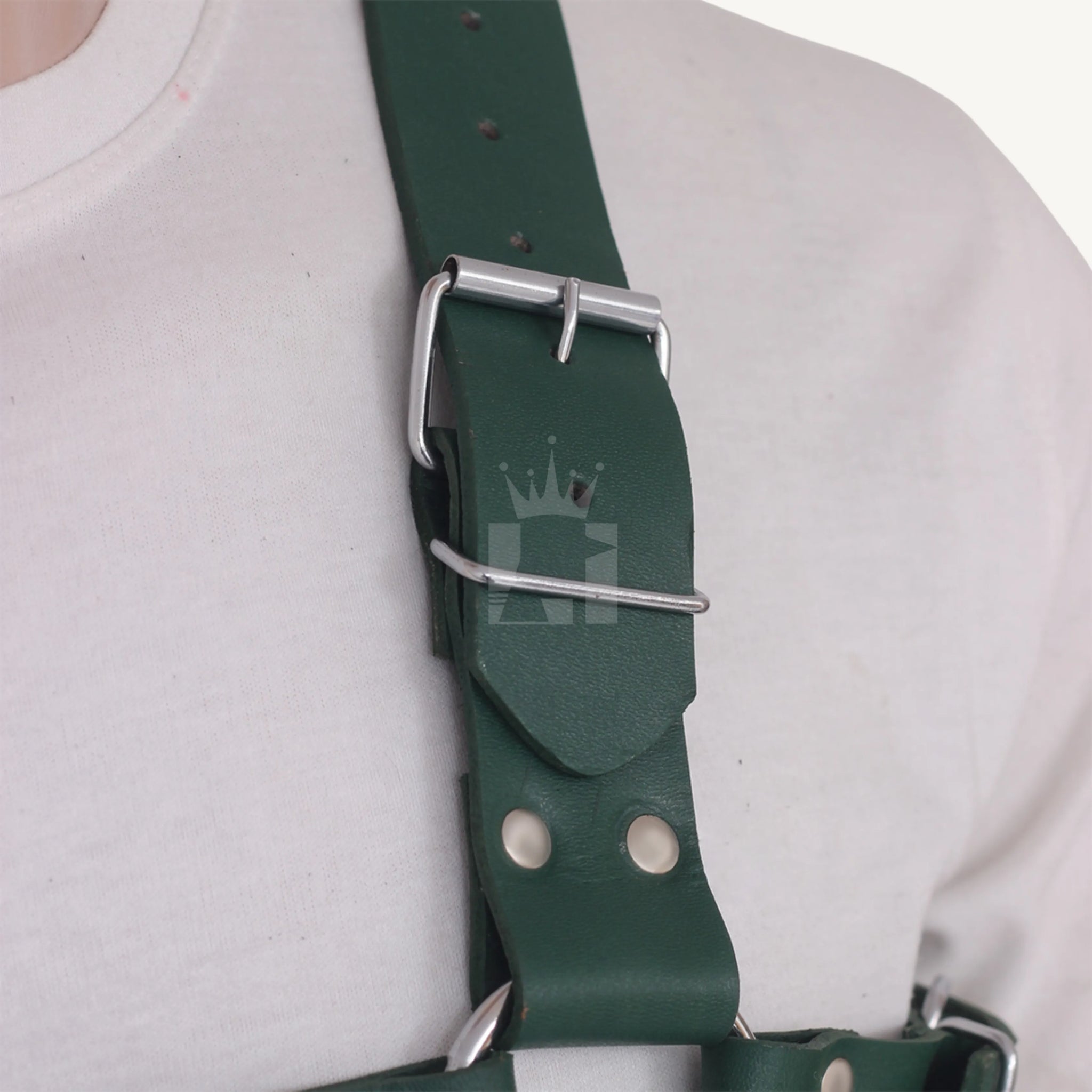 Detailed close-up of adjustable silver buckle on leather chest harness.