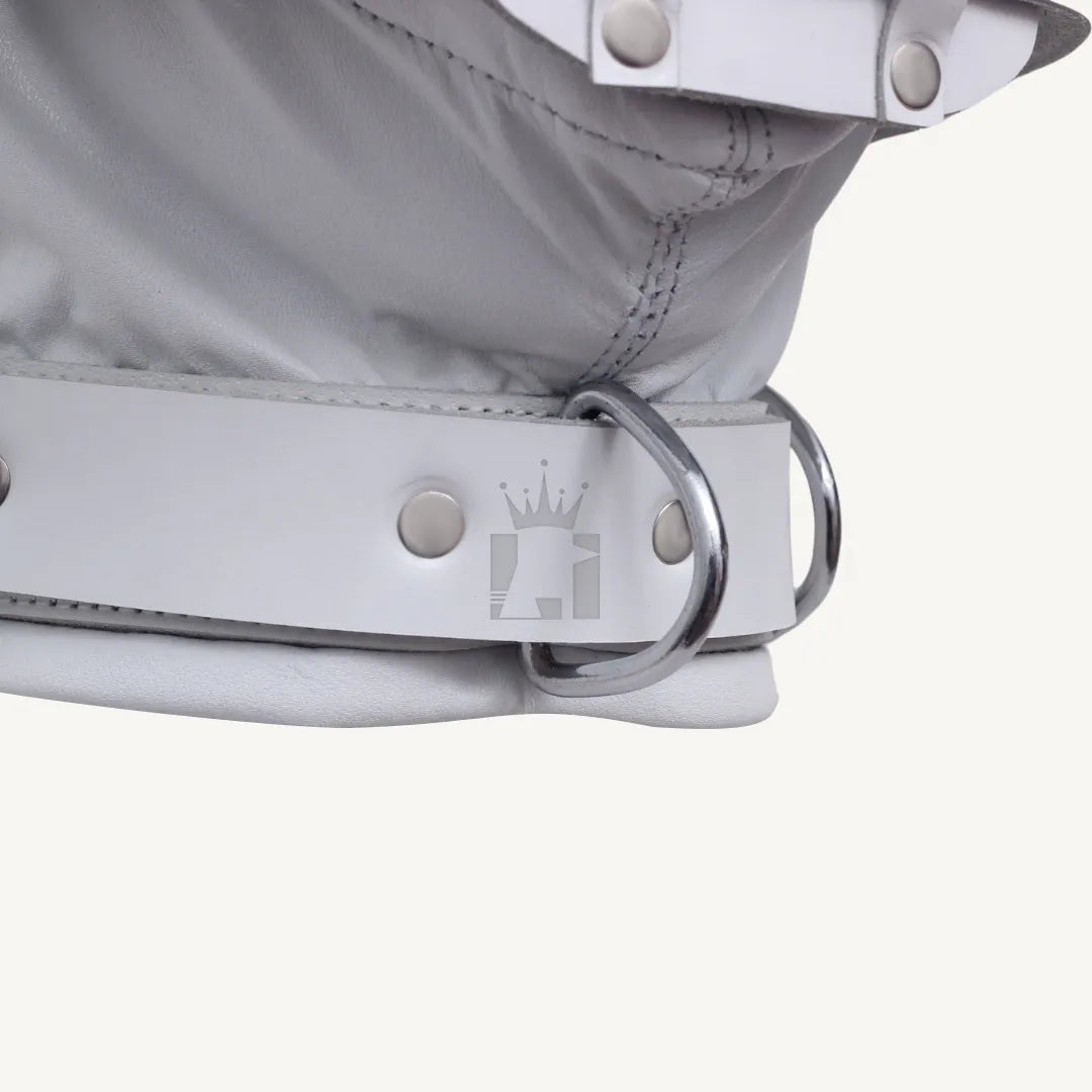 Detailed close-up of silver D-ring attached to bottom strap of white leather bondage hood.