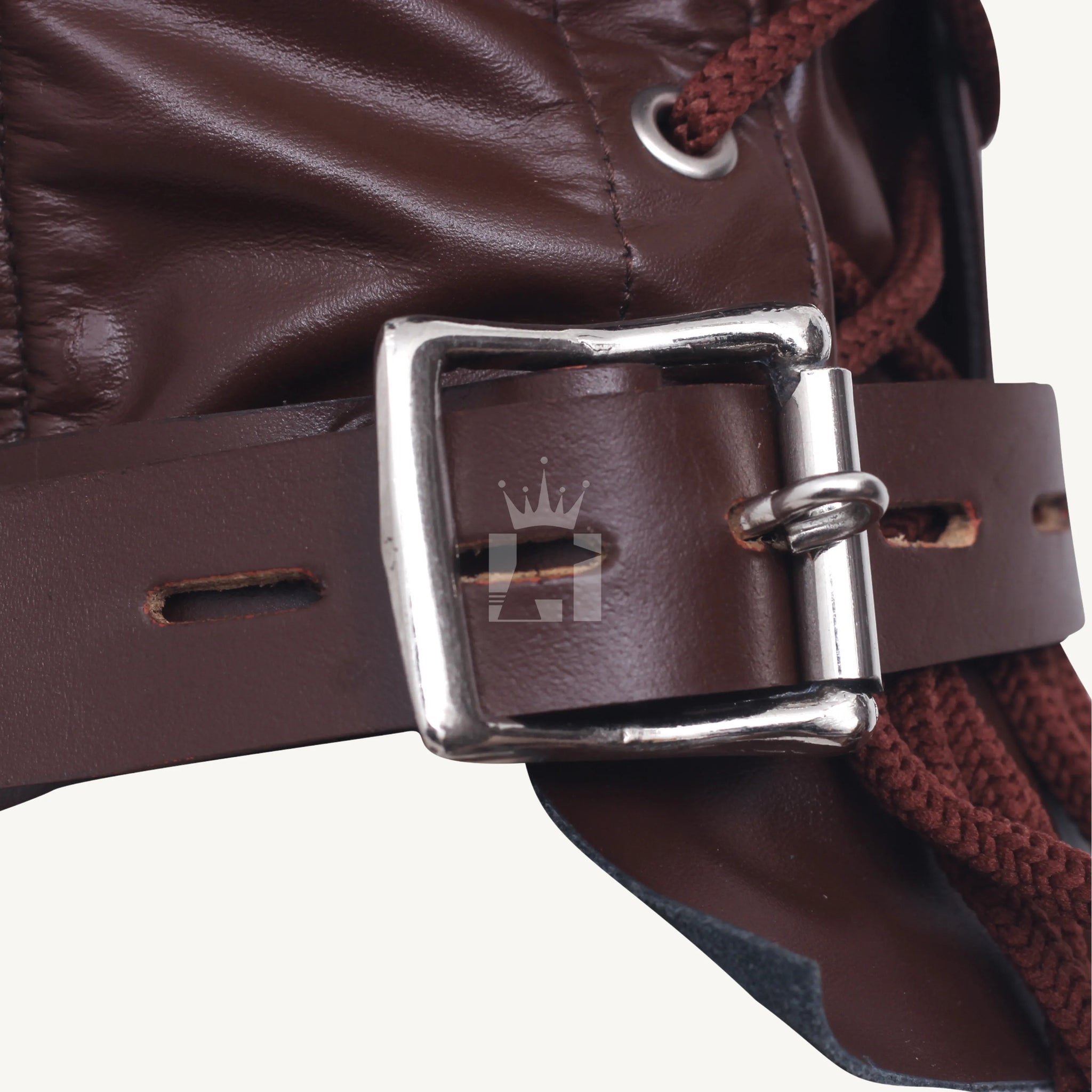 Detailed close-up of the metal buckle and leather strap on a brown leather hood with lacing cord visible.
