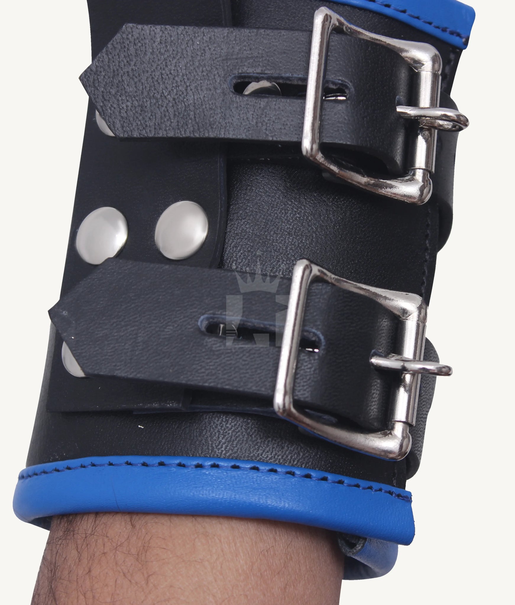 Zoomed-in view of black leather wrist cuff with dual adjustable silver buckles and blue leather trim.