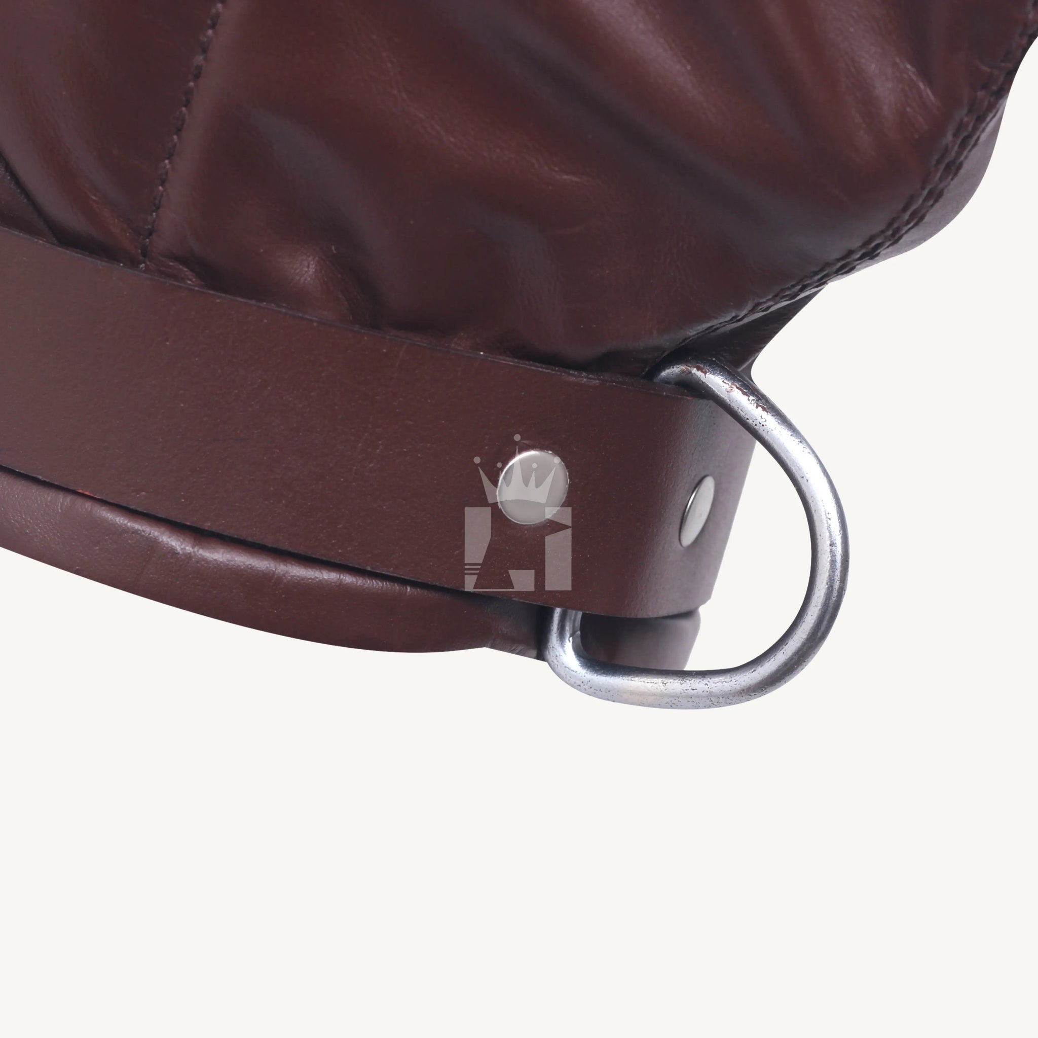 Close-up of the sturdy metal D-ring attached to the bottom strap of a brown leather hood.