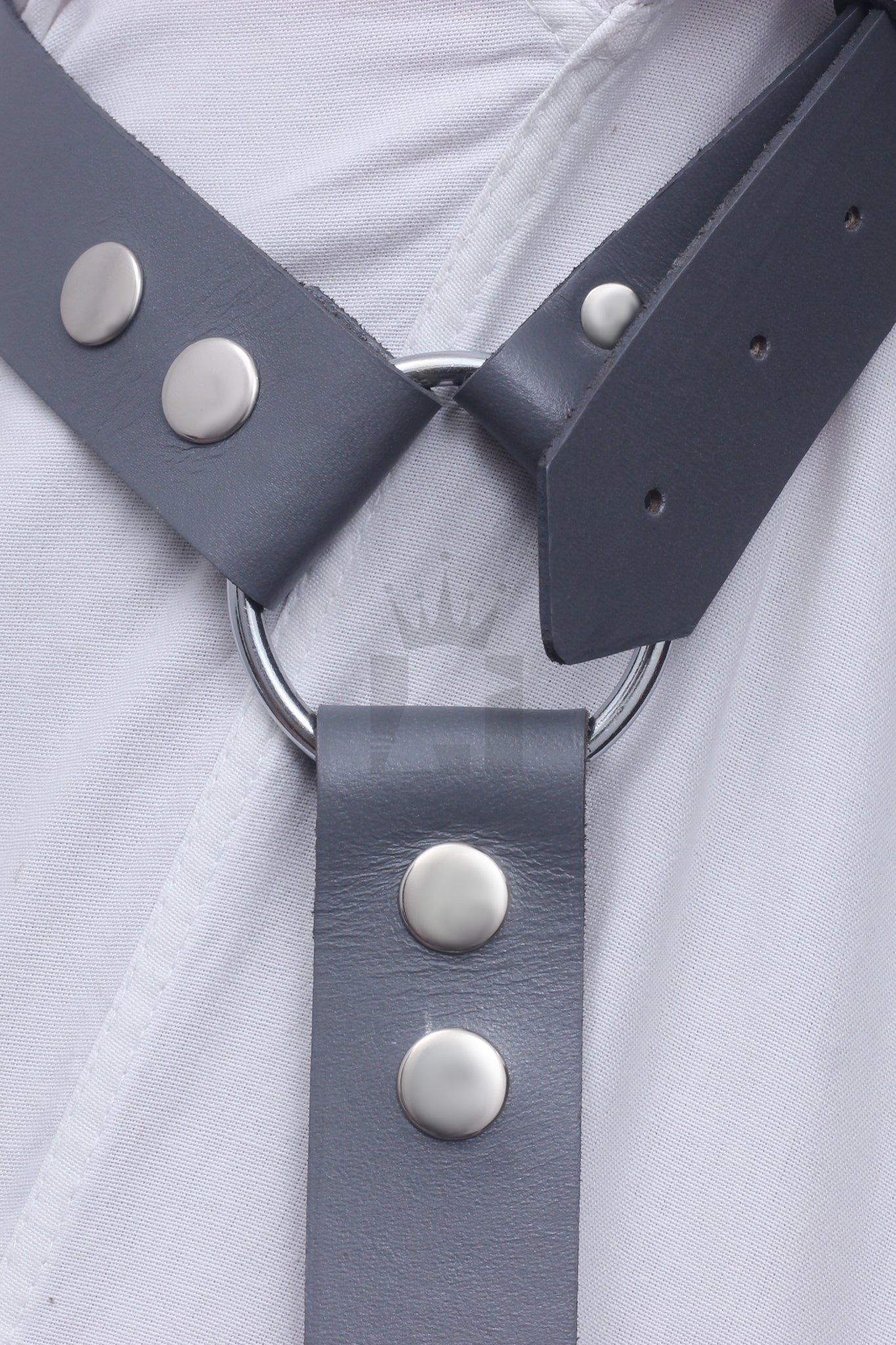 Close-up of O-ring connection with riveted black leather straps on leather chest harness.