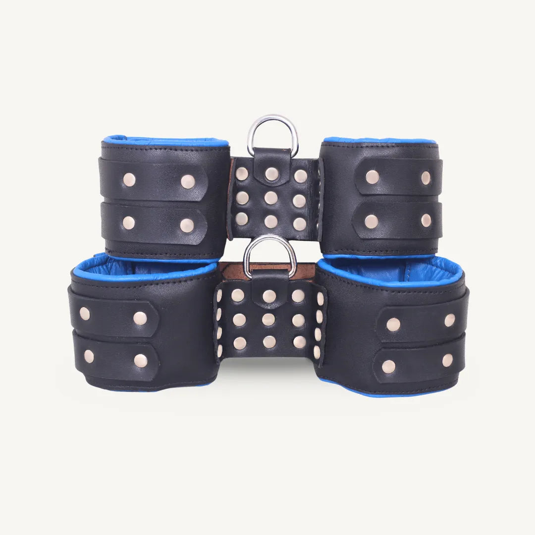 Front display of black and blue padded leather suspension cuffs with heavy-duty rivets and dual D-ring hardware.