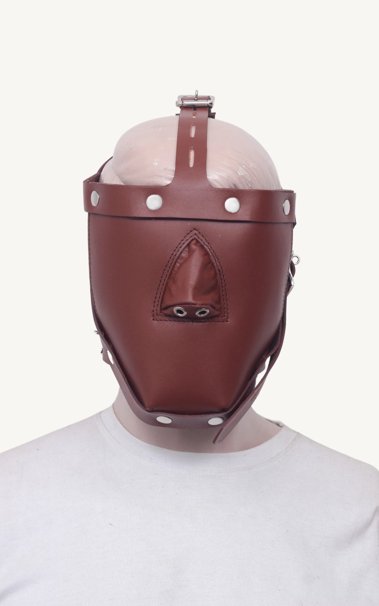 Straight-on view of mannequin wearing a brown leather bondage muzzle with triangular stitched nose cover.