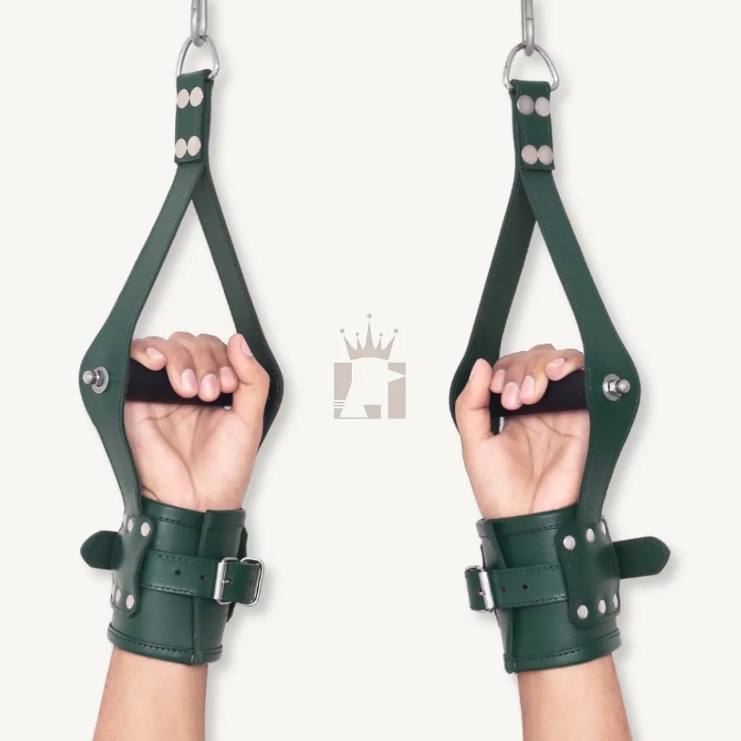 Front view of hands wearing green leather wrist suspension cuffs, gripping black metal rods, hanging from straps.