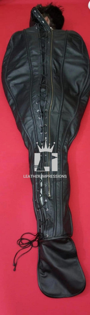 Front angle view of the backside of a handcrafted leather sleepsack with zip in a red background surface