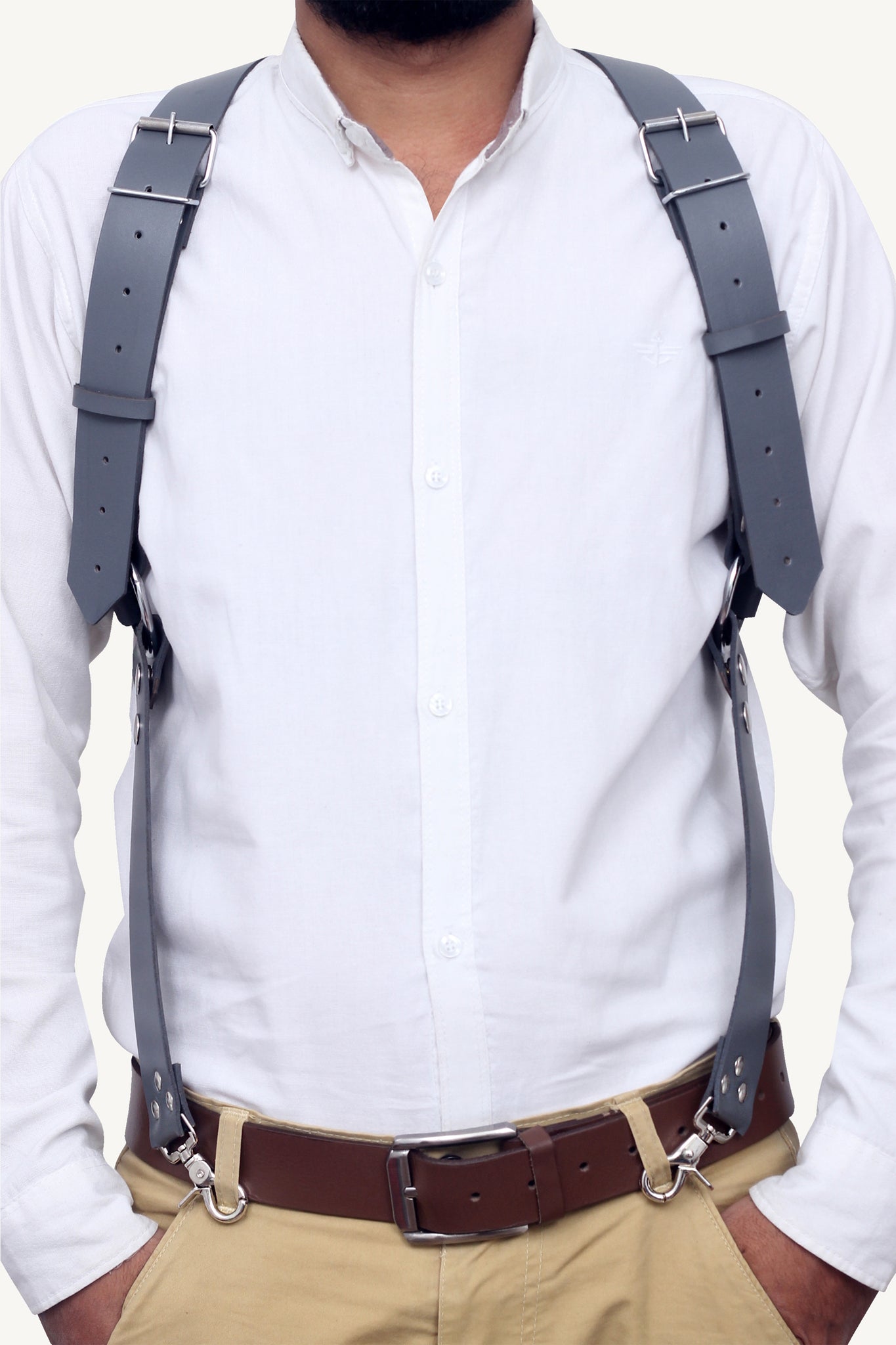 Man in white shirt wearing full leather shoulder harness with metal clips and buckles.