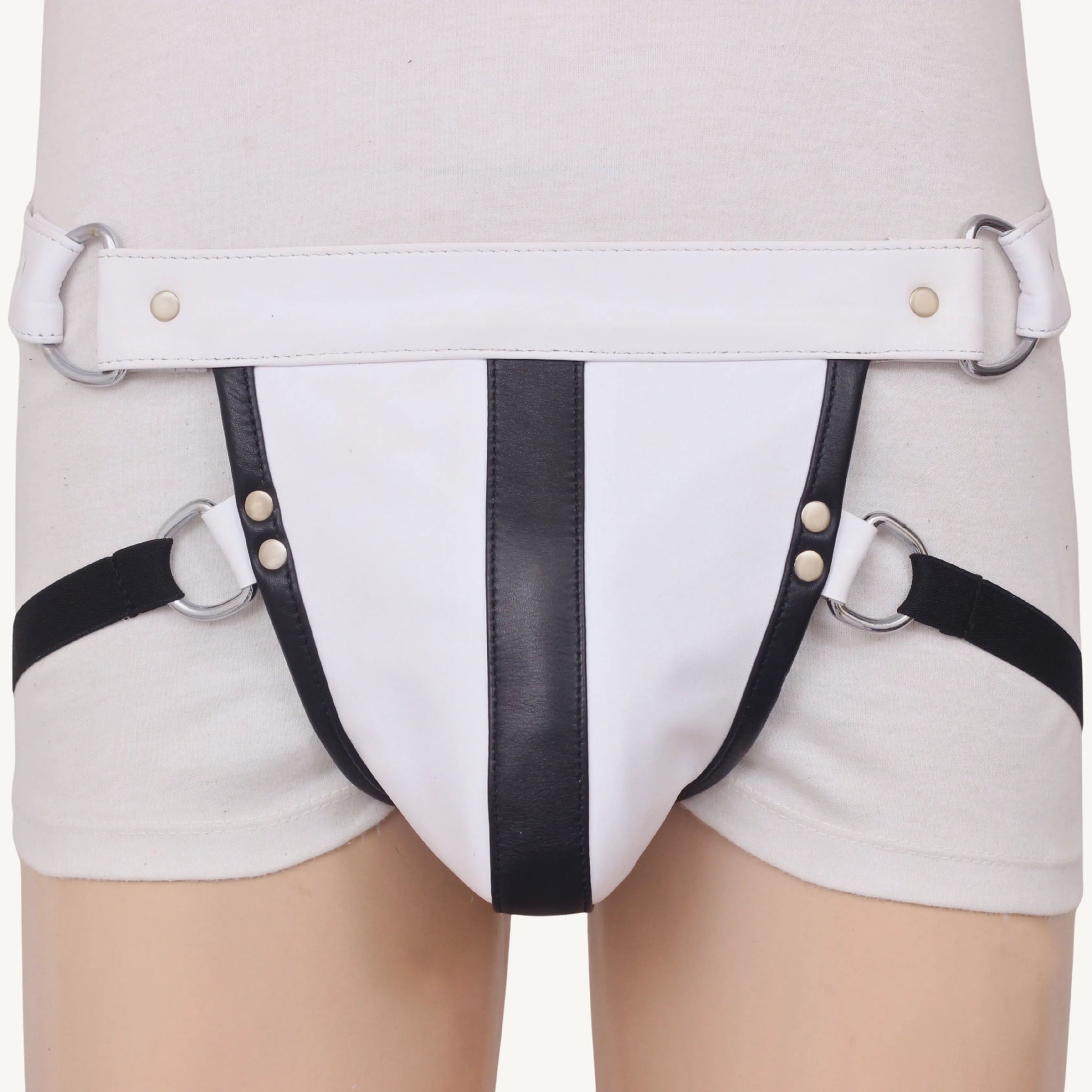 Model wearing white leather jockstrap with bold black vertical stripe and metal D-ring side connections.