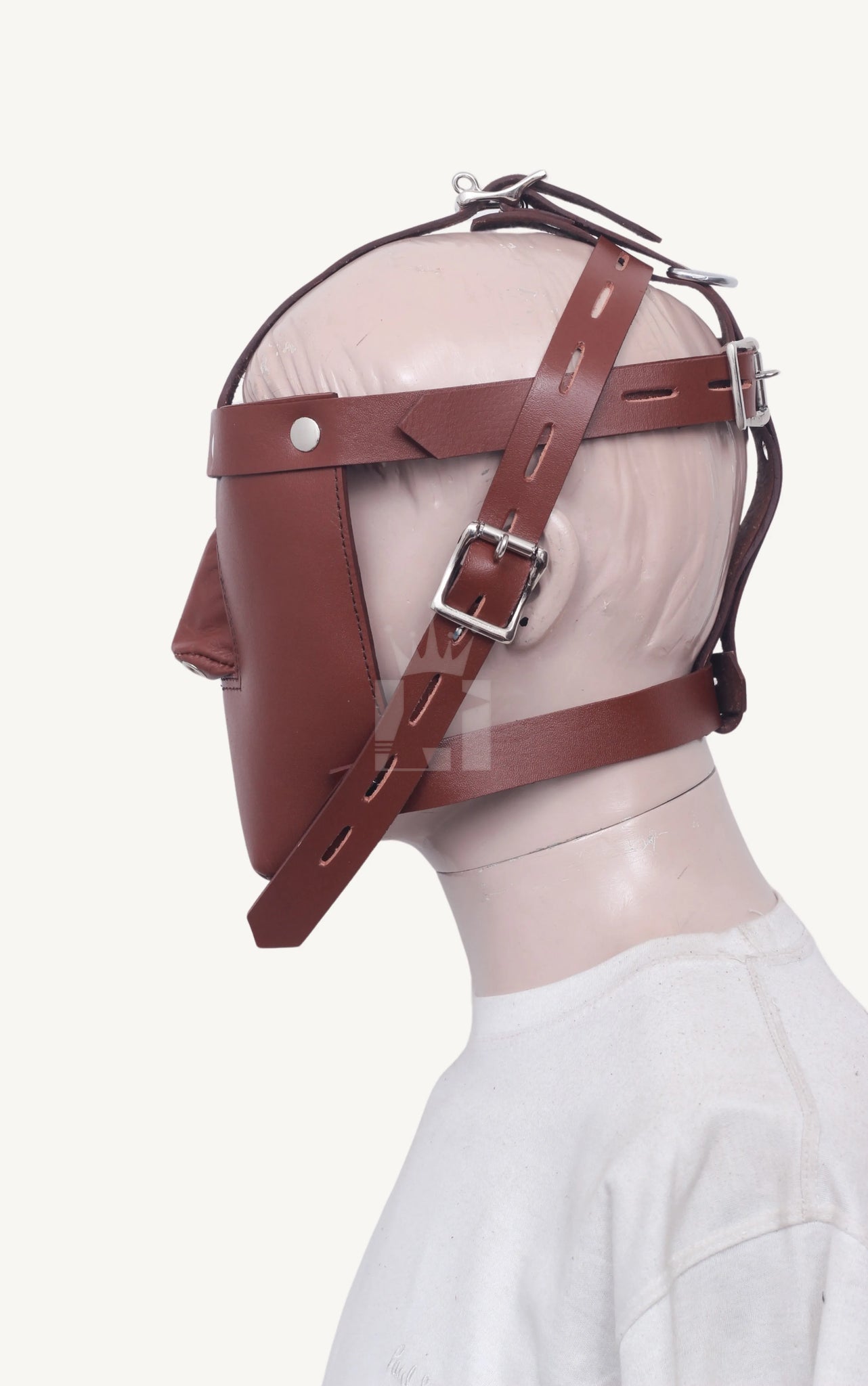 Full side profile of a mannequin head wearing a brown leather bondage muzzle with multiple fastening straps.