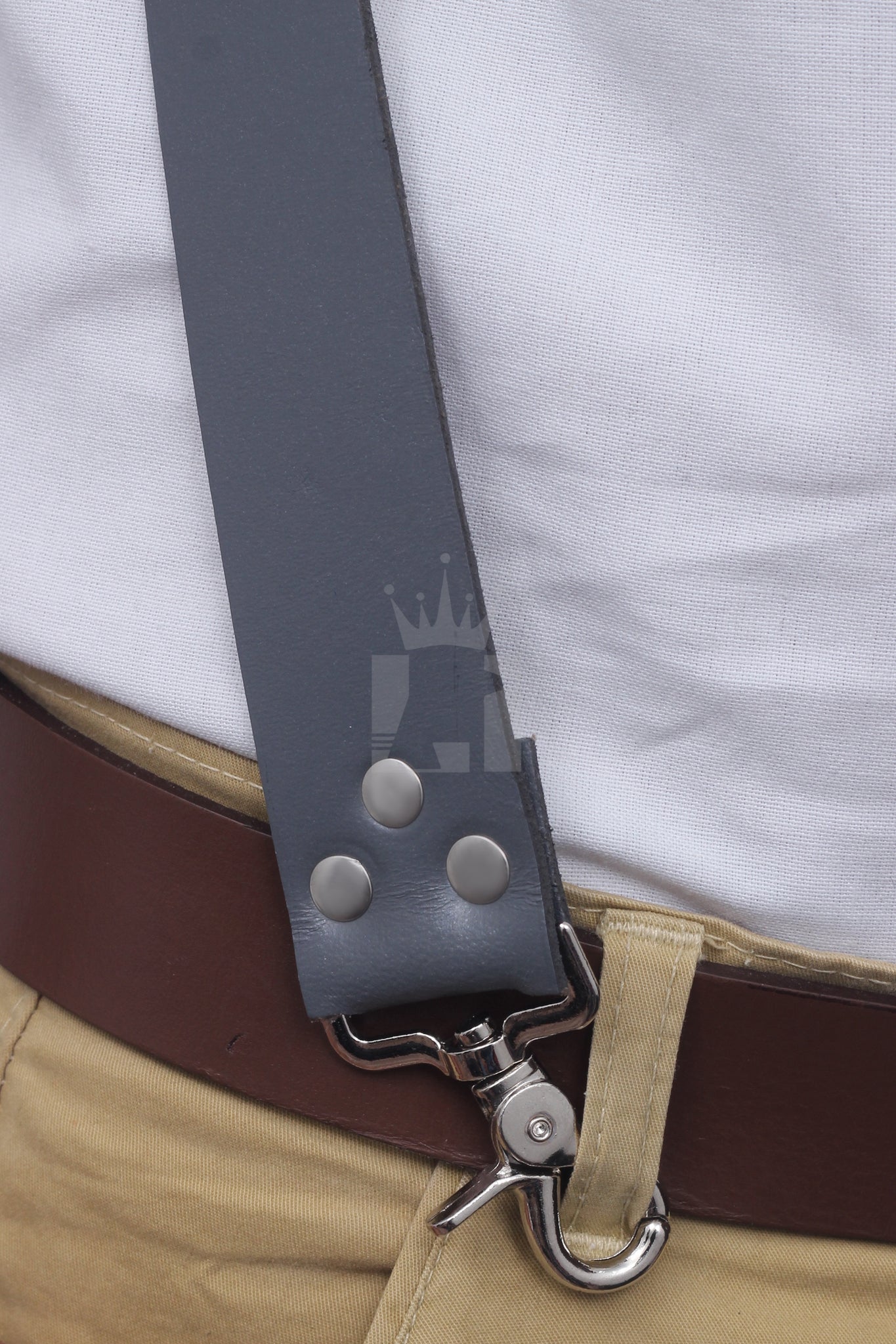 Close-up of leather strap with rivets and metal swivel clip attached to belt loop.