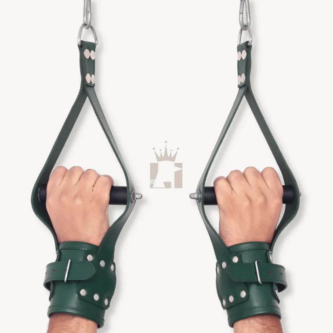 Rear angle view of hands gripping black rods inside green leather wrist suspension cuffs with riveted straps.