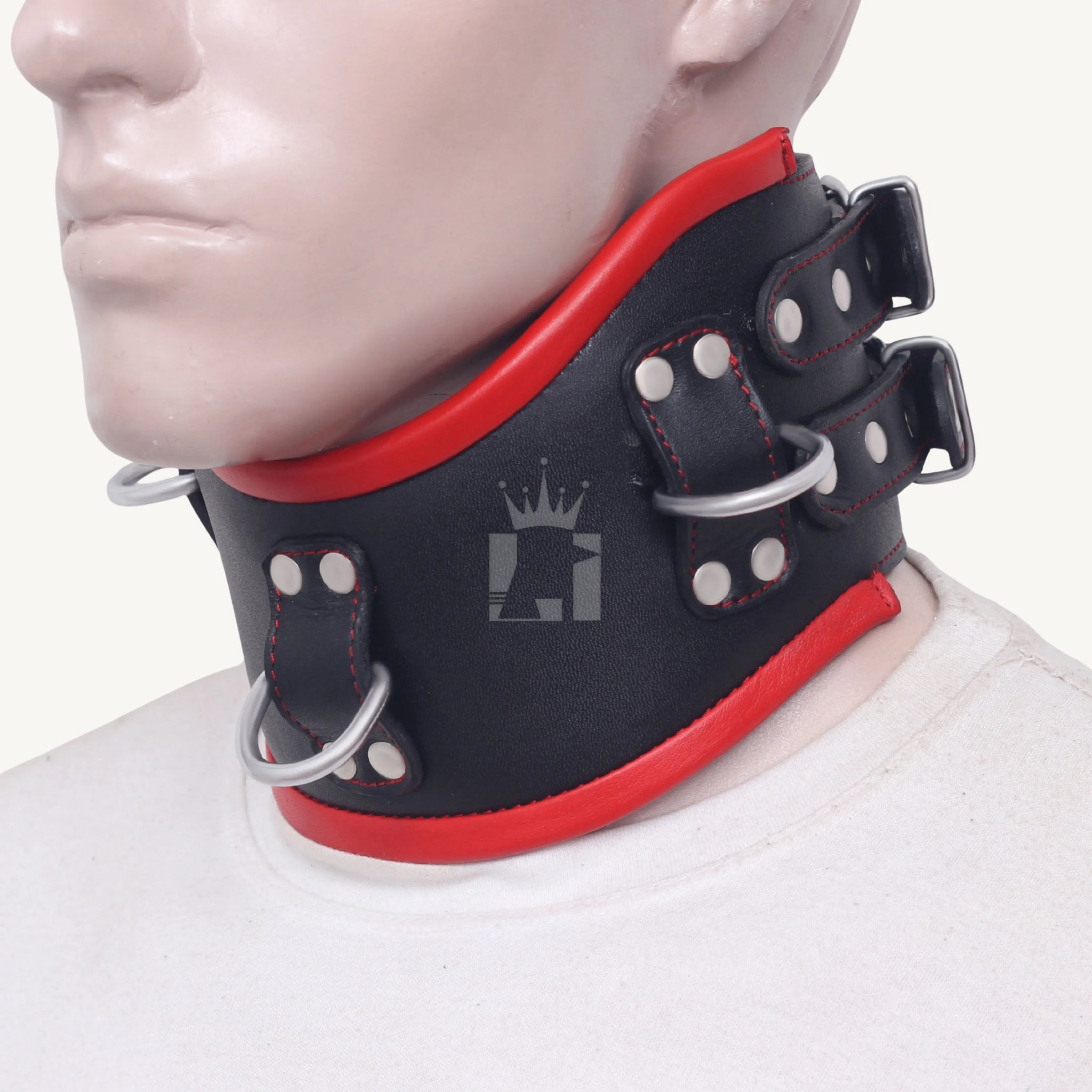 Side view of a black and red leather bondage collar showing double buckle straps and sturdy rivets.