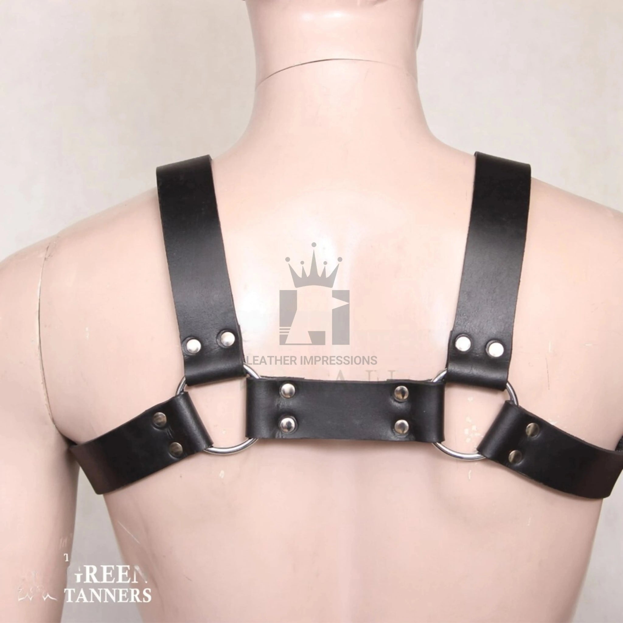 Backside shot of a dummy wearing a black Leather Harness with Multiple O'rings with nickel-plated reverts on a white background 