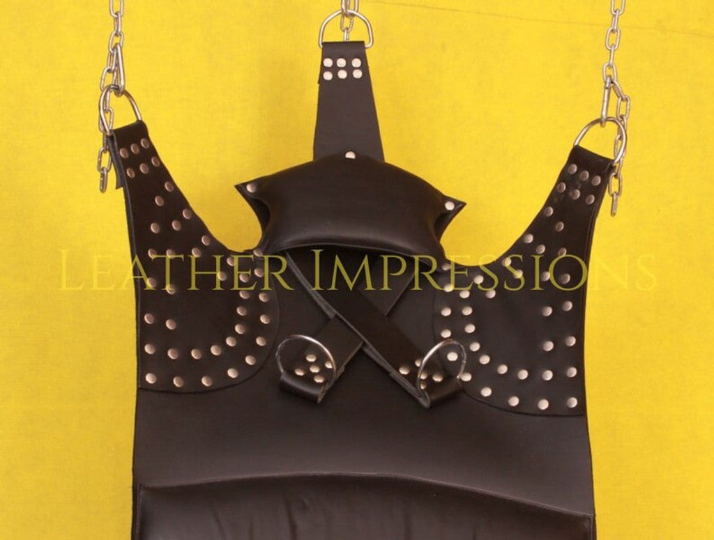 close-up shot of black leather sex swing with comfort pillow,d'ring and nickel-plated reverts on it in a yellow background