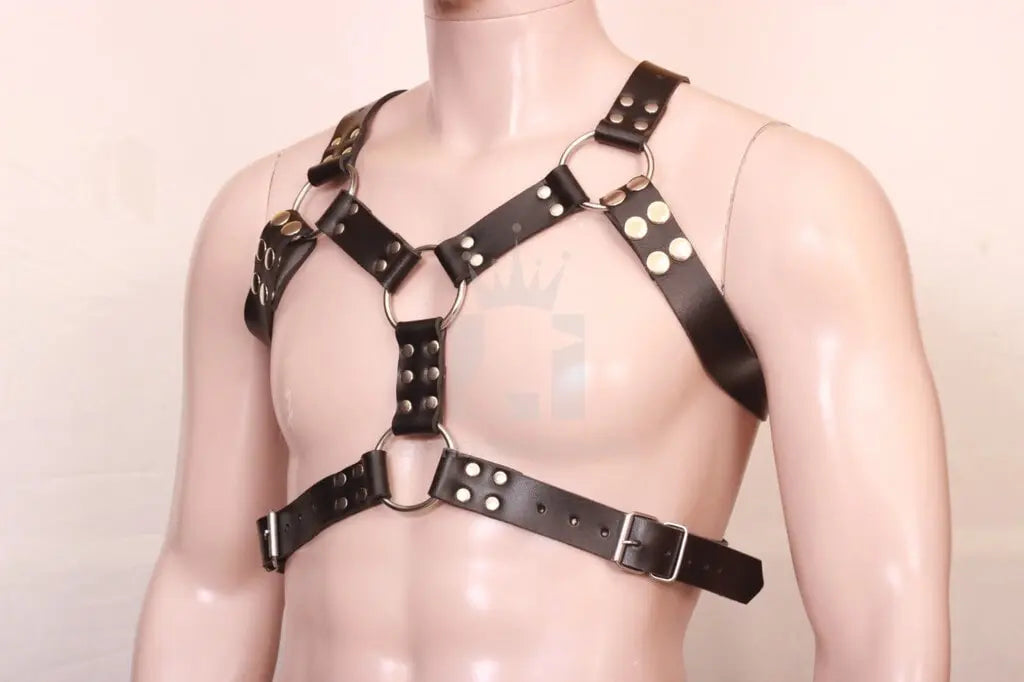 side angle view of a dummy wearing a black leather bondage chest harness with nickel-plated reverts on a white background