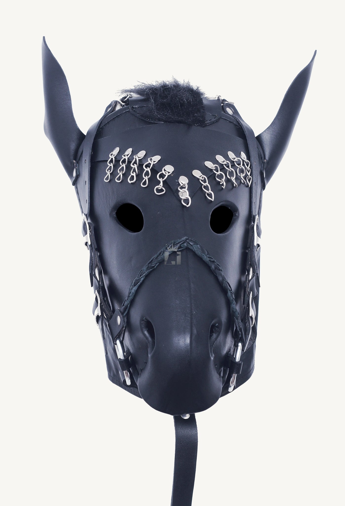 clos-up shot of a Black leather bondage hood designed in the shape of a horse’s head, featuring upright ears, a faux mane, and multiple silver D-rings, buckles, and chain accents. The mask includes a braided leather snout strap, eye openings, and an attached rein-style leash, evoking a pony play aesthetic.