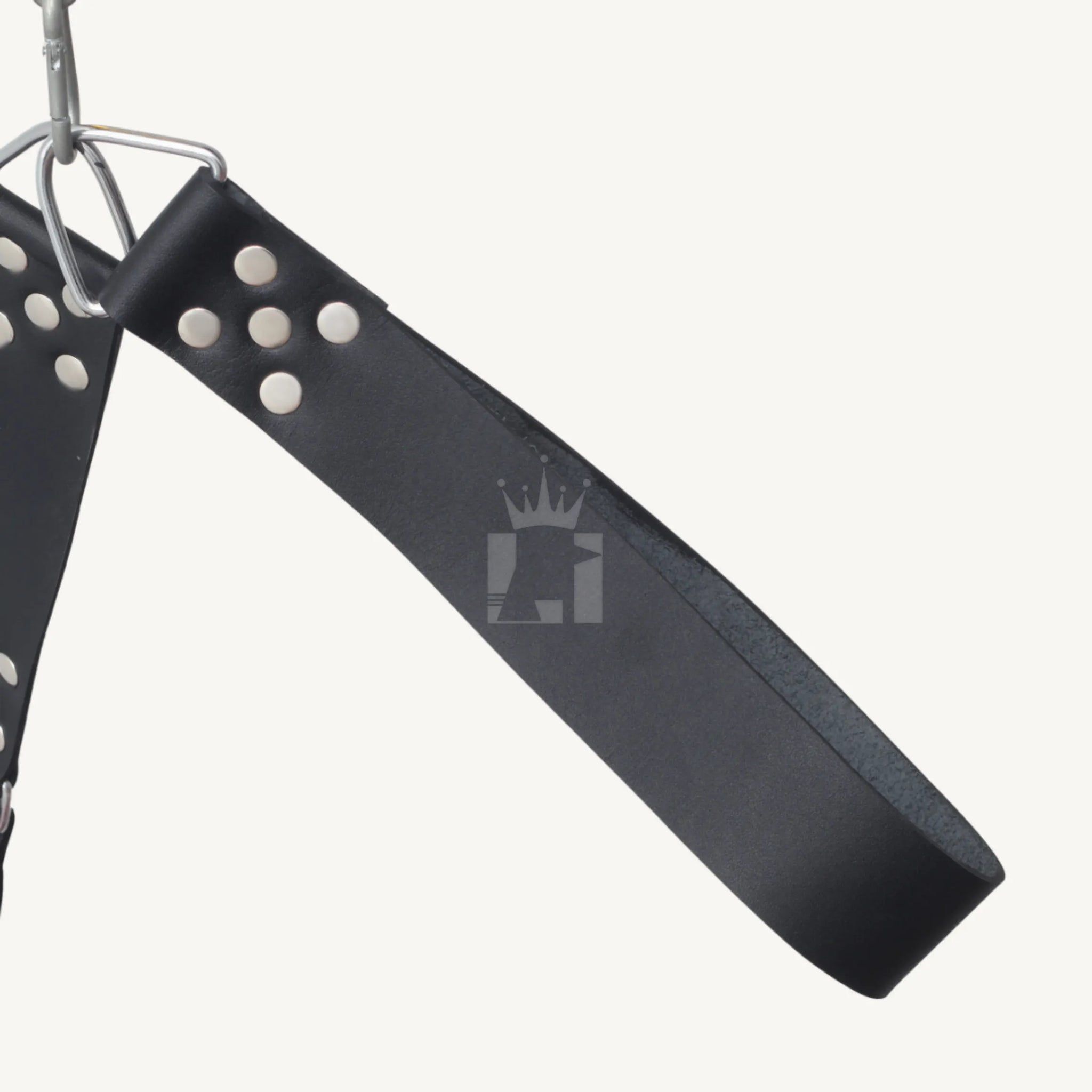 Close-up of black leather strap with steel triangle-ring and rivets for secure sling suspension.
